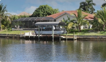 a boat on a doc behind home on the water