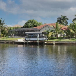 a boat on a doc behind home on the water